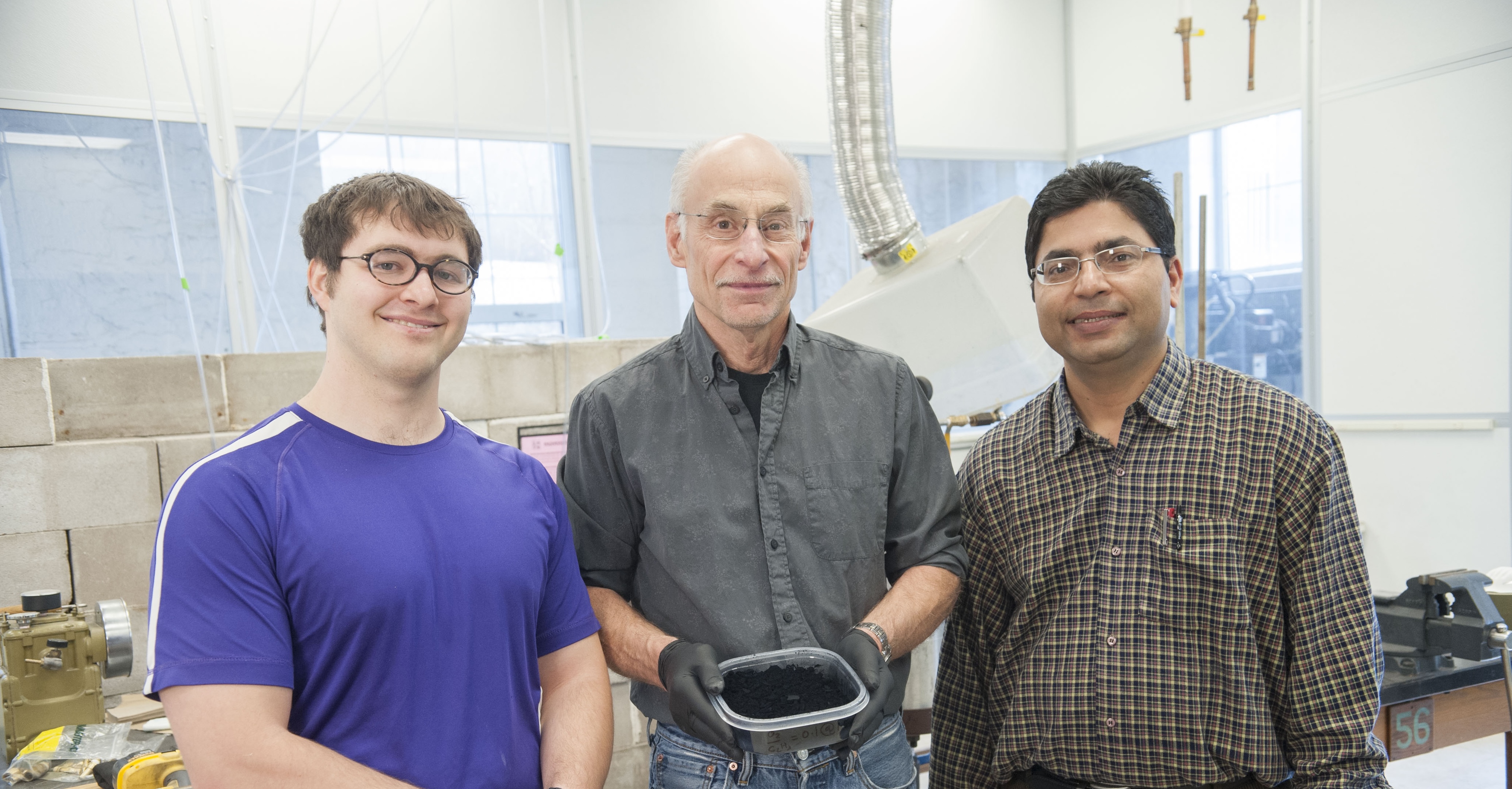 From left: Kansas State University researchers Justin Wright, doctoral student in physics, Camp Hill, Pennsylvania; Chris Sorensen, Cortelyou-Rust&nbsp;university&nbsp;distinguished professor of physics; and Arjun Nepal, postdoctoral researcher and instructor of physics, hold a container of graphene. 