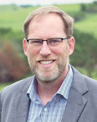 Adam Ahlers smiles for a portrait.