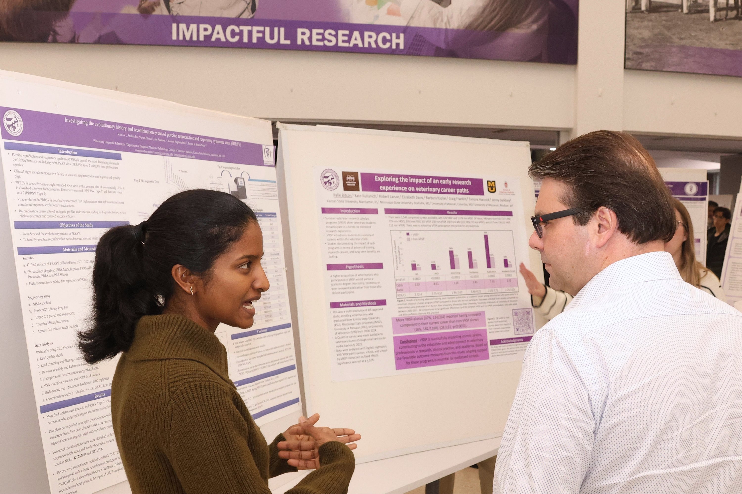 A student explains her research poster during Phi Zeta's research day