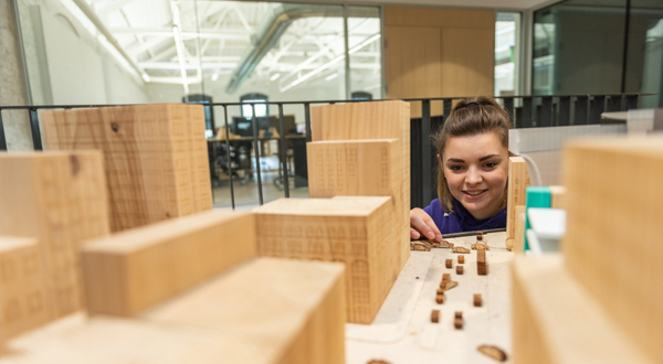 Student looks at model buildings.