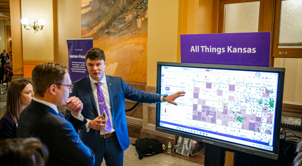 A student shows the All Things Kansas interactive map to Kansas Lt. Gov. David Toland.