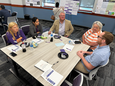 A group gathers around a table to discuss water-related projects