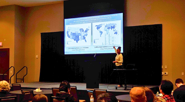 OEIE team member presenting data with maps on a projector screen