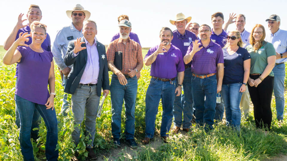 President Linton in a field with community members during a regional visit.