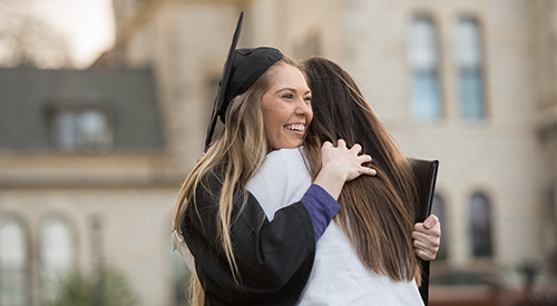 Alum hugging parent after graduation