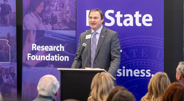 This image shows a man speaking at a podium