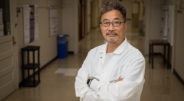 A man in a white lab coat poses for a portrait.