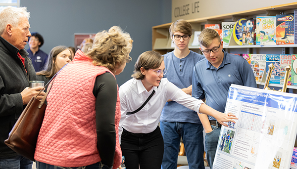 Students presenting a poster to community members