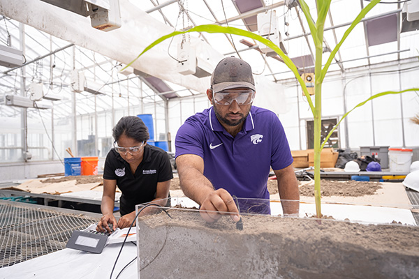 Two researchers studying soil