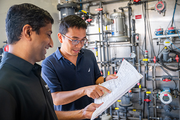 Two researchers collaborating and pointing to a paper