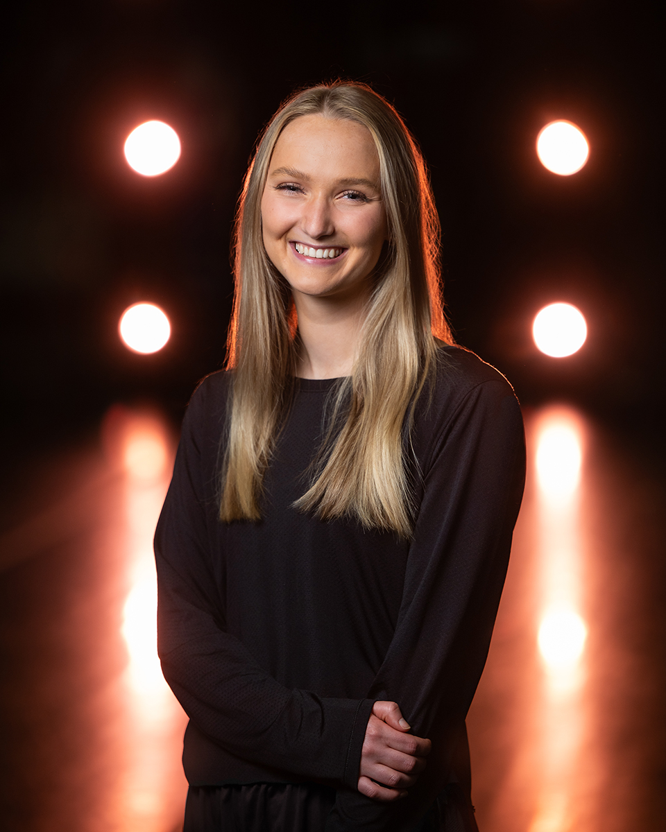 Abbey Griffin poses for a portrait with bright lights behind her..